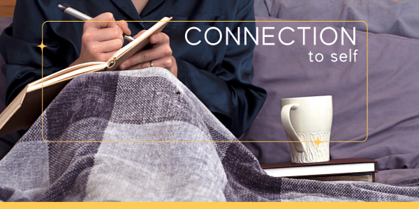 Woman sitting in bed, cropped from the shoulders down, writing in a journal with a cup of coffee at her side—illustrating relaxed, thoughtful journaling techniques for emotional regulation.