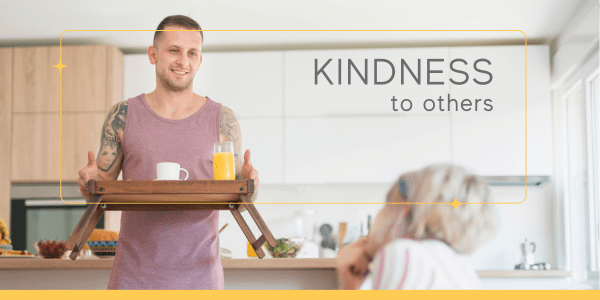 A man smiling as he serves breakfast on a tray to a seated woman, illustrating Kindness to others—one of the effective techniques for emotional regulation through generous and intentional actions.